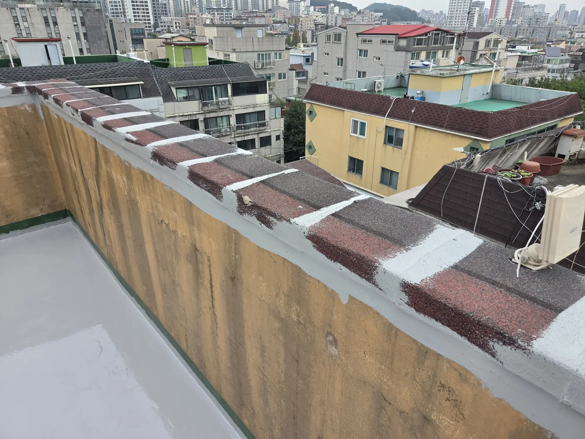 난간 두겁과 바닥 가장자리에 보수재를 시공한 화곡동 옥상