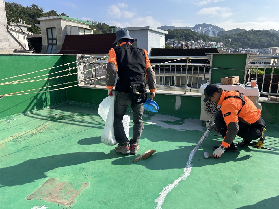 난곡로 옥상 기존 도막의 균열을 따라 코킹하는 작업자