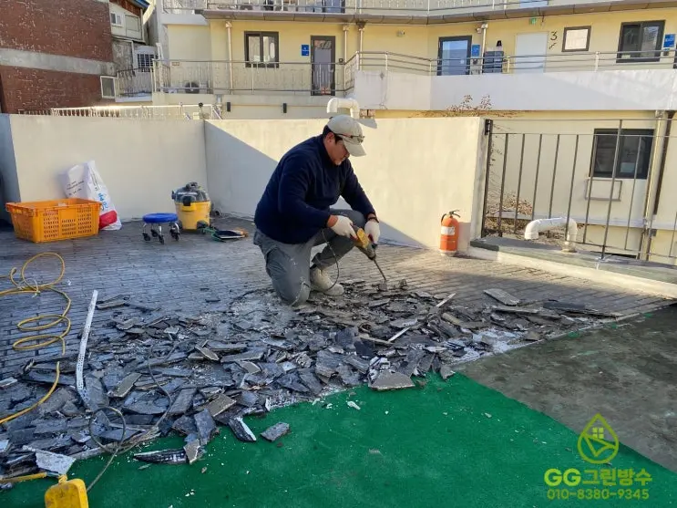 청파동 게스트하우스 옥상의 타일과 인조잔디를 철거하는 모습