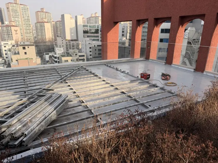데크를 걷어 드러낸 잠원동 옥상 방수층과 상도 작업 구간