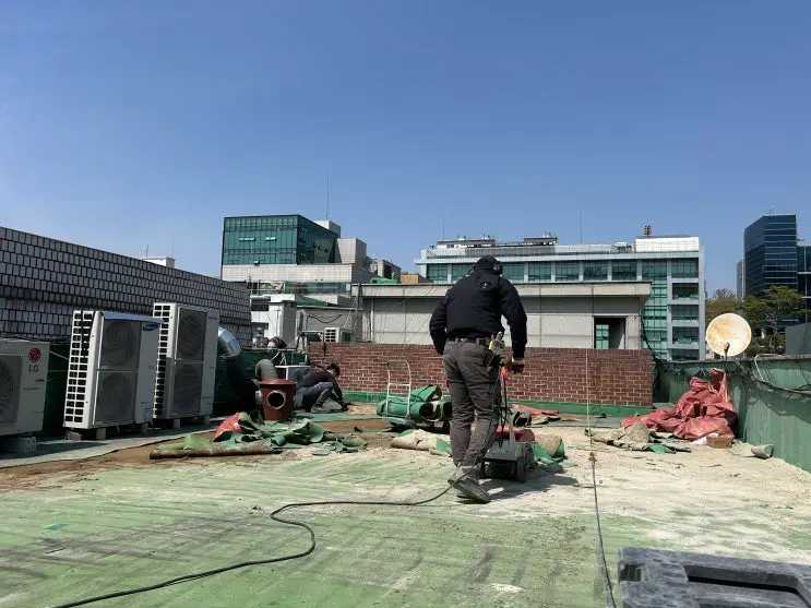 녹번동 옥상에서 들뜬 기존 방수층을 기계로 철거하는 모습